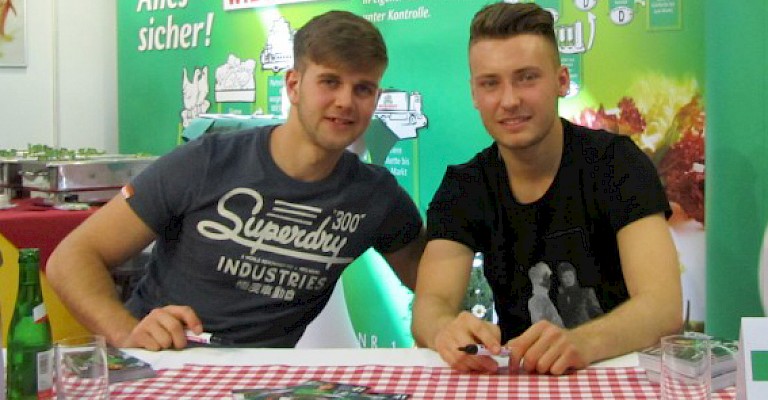 Niclas Füllkrug (links) und Tom Trybull vom SV Werder Bremen unterschrieben am WIESENHOF Stand Autogrammkarten für ihre Fans.